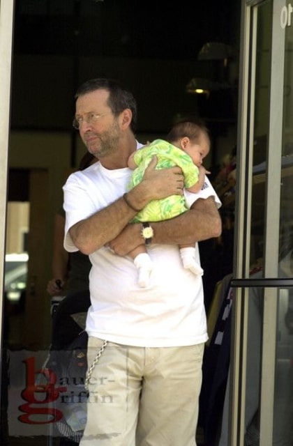 Musician Eric Clapton holding her daughter Julie Rose Clapton